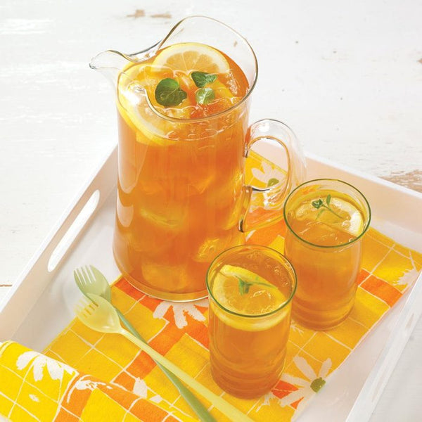 Pitcher of iced tea with two glasses on serving tray.