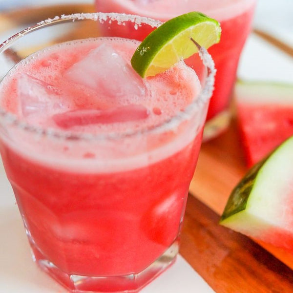 Closeup of glass with mocktail, including watermelon on the side.