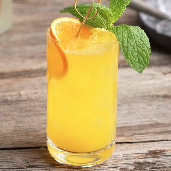 Image of orange mint mocktail in pint glass.